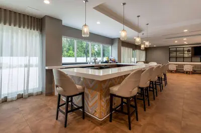 a large kitchen with a bar with stools at Wyndham Garden Orlando Airport - Free Airport Shuttle in Orlando