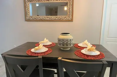 a dining room table with plates and a vase on it at LUXURY and VINTAGE space to enjoy your vacation!! in Kissimmee