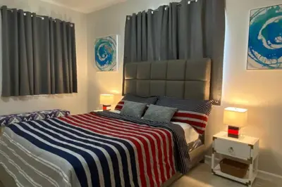 a bedroom with a bed with a striped blanket and two lamps at LUXURY and VINTAGE space to enjoy your vacation!! in Kissimmee