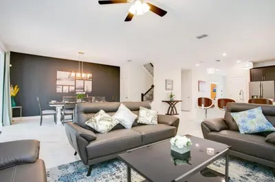 a living room with a couch and a table at 9 Bed Storey Lake Resort Game Room Pool home in Kissimmee