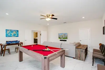 a living room with a red pool table at 9 Bed Storey Lake Resort Game Room Pool home in Kissimmee