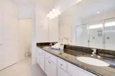 a bathroom with a sink and a large mirror at 5 Bed 5 Bath in 5 Star Resort Near Disney! home in Kissimmee