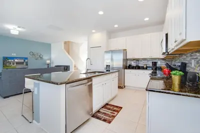 a large kitchen with white cabinets and appliances at 5 Bed 5 Bath in 5 Star Resort Near Disney! home in Kissimmee