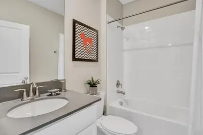 a white bathroom with a sink and a toilet at Boutique Style Home Near Disney! home in Kissimmee