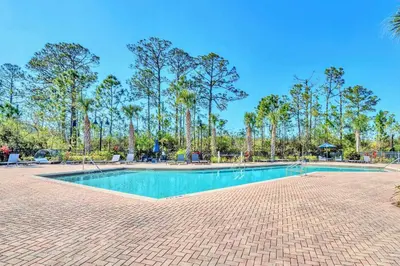 a swimming pool with trees in the background at Stunning 3BR Near Disney - Pool in Orlando