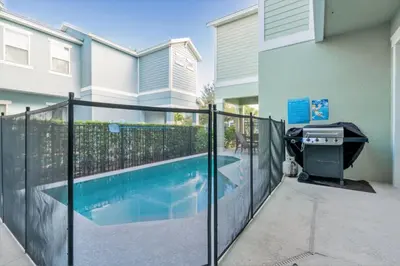 a swimming pool with a fence next to a house at Beautiful Home Near Disney with Private Pool! villa in Orlando