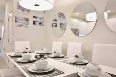 a dining room with a table with dishes and mirrors at Amazing 3 bedroomloft townhouse in Hidden Forest, with private pool! in Orlando
