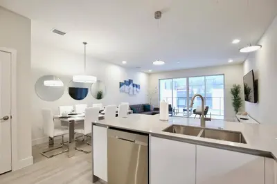 a kitchen with a sink and a table with chairs at High luxury 3 bedroomloft townhouse in Hidden Forest, with private pool! in Orlando
