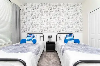 two twin beds in a room with a wall at Gorgeous 5BDR Family with Pool at Storey Lake 2767 O in Kissimmee