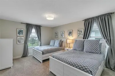a bedroom with two beds and two windows at 5 Bed Storey Lake Home Lazy River Resort villa in Kissimmee