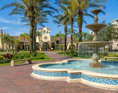 a fountain in front of a building with palm trees at Vista Cay Resort by Millenium at Universal Blvd. in Orlando