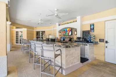 a large kitchen with a bar with stools at Vista Cay Resort by Millenium at Universal Blvd. in Orlando