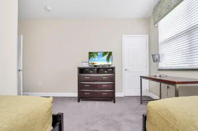 a bedroom with two beds and a desk and a tv at 3 bed Town Home With Splash Pool! townhouse in Orlando