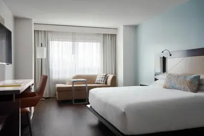 a hotel room with a bed and a chair and a desk at Marriott Orlando Downtown in Orlando