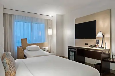 a hotel room with two beds and a television at Marriott Orlando Downtown in Orlando