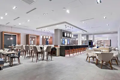 a restaurant with tables and chairs and a bar at Marriott Orlando Downtown in Orlando