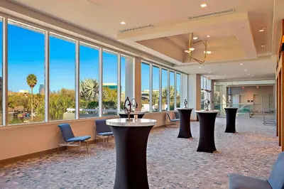 a lobby with tables and chairs and large windows at Marriott Orlando Downtown in Orlando
