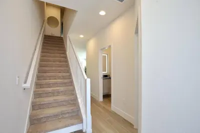 a staircase in a home with white walls and wooden floors at Great 4 bedroom townhouse in Hidden Forest, with private pool! in Orlando