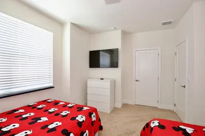 a bedroom with a red bedspread with cows on it at Great 4 bedroom townhouse in Hidden Forest, with private pool! in Orlando