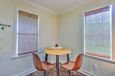 a table and two chairs in a room with two windows at 16 Mi to Disney Cottage with Deck in Winter Garden in Orlando