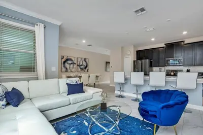 a living room with a white couch and a blue chair at Brand New Storey Lake Resort With Water Slides townhouse in Kissimmee