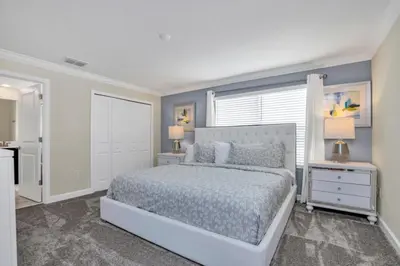 a bedroom with a large bed and two night stands at Brand New Storey Lake Resort With Water Slides townhouse in Kissimmee
