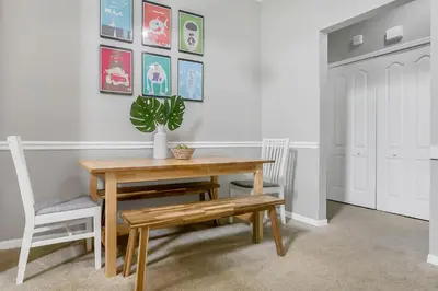 a dining room with a wooden table and a potted plant at Cozy Apartment Only Miles From Disney Community Pool And Jacuzzii in Kissimmee