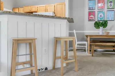 two wooden stools in a room with a table at Cozy Apartment Only Miles From Disney Community Pool And Jacuzzii in Kissimmee