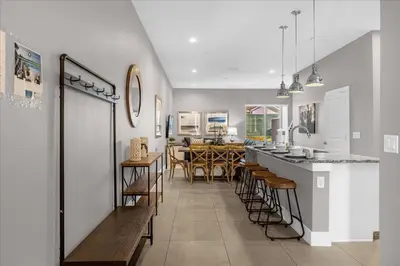a kitchen and dining room with a bar and chairs at Magical Vacation Home 3 min from Disney in Orlando