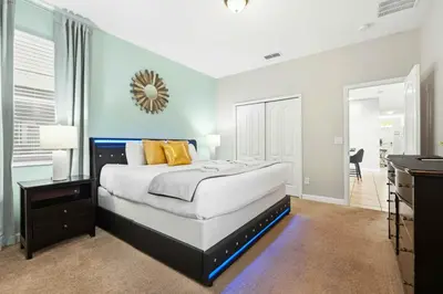 a bedroom with a large bed and a mirror on the wall at Appealing, Large 5BD Home Close to Themed-Parks #5PP961 in Kissimmee