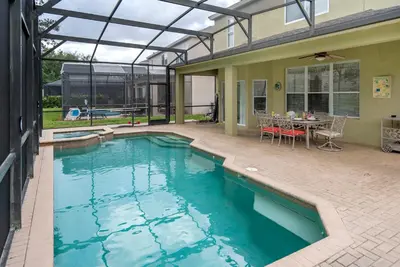 a swimming pool in a house with a table and chairs at Spacious 6BR Villa Pool Parking Near Disney World in Orlando