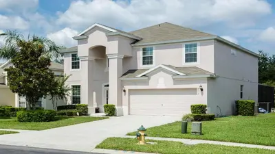 a house with a fire hydrant in front of it at Spacious 6BR Villa with Pool SPA 3 Miles to Disney in Orlando