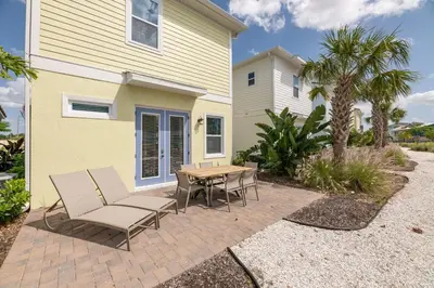 a patio with chairs and a table in front of a house at Sunrise Cottage Near Disney With Margaritaville Resort & Island H20 Waterpark Access - 2966Sr in Orlando