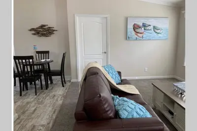 a living room with a brown couch and a table at Resort Cottage near parks at Great Price! in Kissimmee