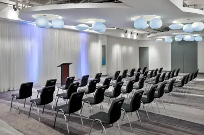 a conference room with a row of chairs and a podium at Aloft Orlando Downtown in Orlando