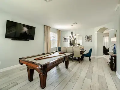 a living room with a pool table and a dining room at Luxury Family Villa Pool Hot Tub Close to Disney in Orlando