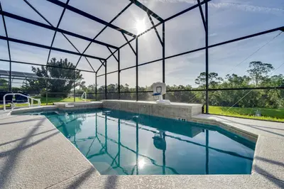 an indoor swimming pool with a large glass building at Spacious Kissimmee Family Home with Game Room and Pool in Kissimmee