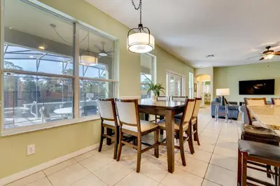 a dining room and living room with a table and chairs at Spacious Kissimmee Family Home with Game Room and Pool in Kissimmee