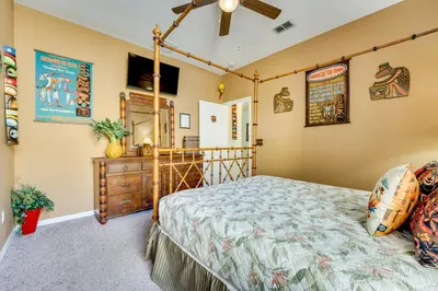 a bedroom with a bed and a dresser at Spacious Kissimmee Family Home with Game Room and Pool in Kissimmee