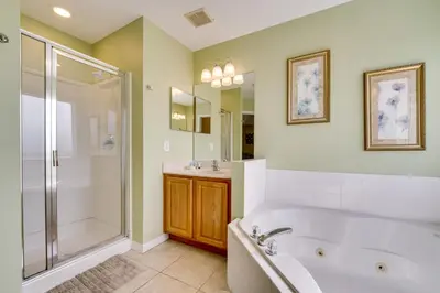 a bathroom with a tub and a shower and a sink at Spacious Kissimmee Family Home with Game Room and Pool in Kissimmee