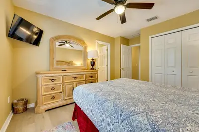a bedroom with a bed and a dresser with a mirror at Spacious Kissimmee Family Home with Game Room and Pool in Kissimmee