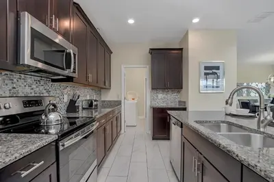 a kitchen with a sink and a stove top oven at LAKEVIEW Home w Private Pool FREE Water Park in Kissimmee