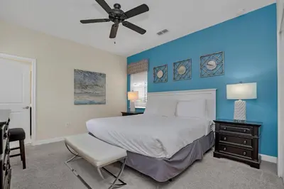 a bedroom with a bed and a blue wall at LAKEVIEW Home w Private Pool FREE Water Park in Kissimmee