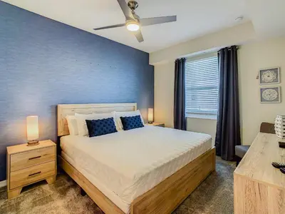 a bedroom with a bed and a blue wall at Cute Lakeview 2BR Condo with 2 Clubhouses in Kissimmee