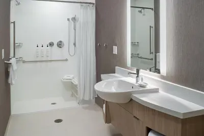 a white bathroom with a sink and a shower at SpringHill Suites by Marriott Winter Park in Orlando