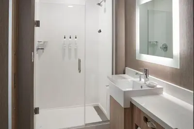a bathroom with a sink and a shower with a mirror at SpringHill Suites by Marriott Winter Park in Orlando