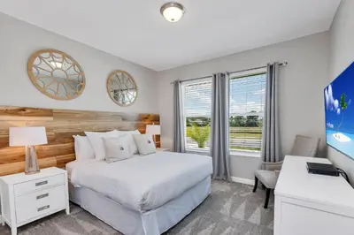a bedroom with a bed and a desk and a window at Lovely Private Pool Villa wFREE Resort Access in Kissimmee