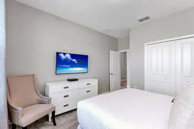 a bedroom with a bed and a chair and a tv at Lovely Private Pool Villa wFREE Resort Access in Kissimmee
