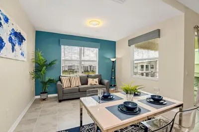 a living room with a table and a couch at Cozy Condo Near Disney wPool View FREE WaterPark in Kissimmee