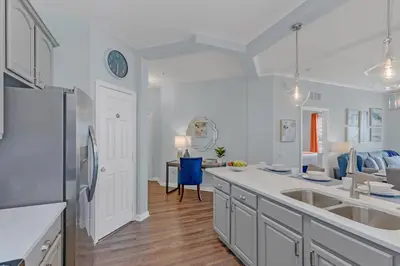 a kitchen with white cabinets and a white refrigerator at Top floor condo with view of lake, pool and fireworks! Next to Convention Center! in Orlando